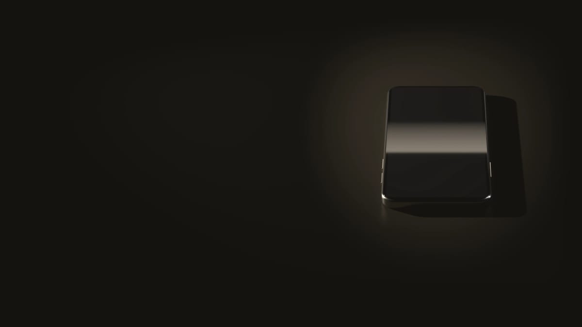Un téléphone posé à plat, l’écran éteint